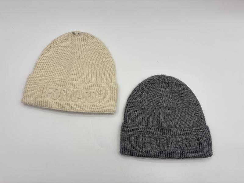 Two ribbed knit beanie hats in cream and grey with embossed Forward logo on folded cuff, laid flat on white surface