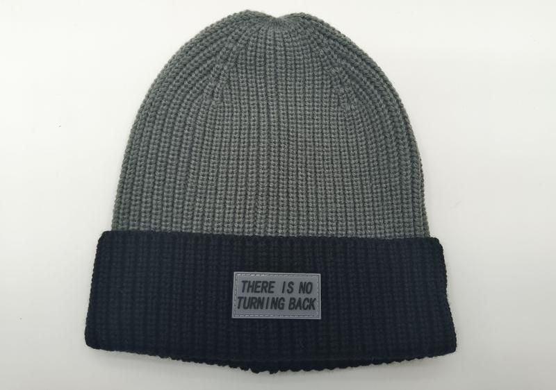 Gray and black two-tone ribbed knit winter beanie with 'There Is No Turning Back' rubber label patch on dark cuff