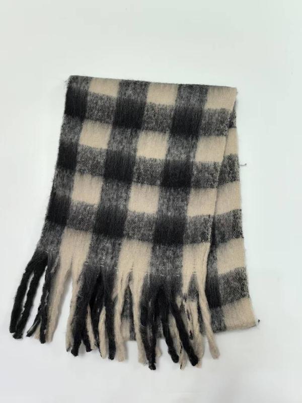 Folded black and cream large buffalo plaid winter scarf with tassel fringe ends on white background