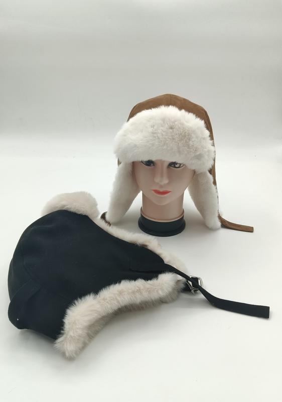 Two trapper ushanka hats with white faux fur trim displayed on mannequin head and flat surface, brown suede and black versions