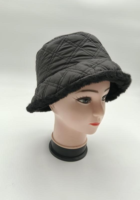 Dark gray quilted bucket hat with black faux fur brim trim displayed on a female mannequin head, product catalog shot