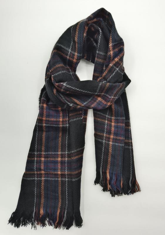 Dark black tartan plaid scarf with orange, blue, and grey check pattern, looped and draped with fringe ends on white background