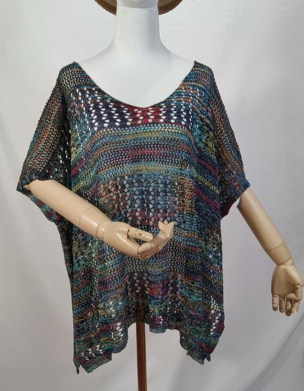 Multicolor open-knit crochet boho poncho top with short sleeves displayed on a mannequin, featuring teal, red, and gold tones