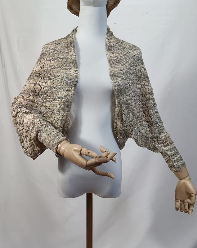 Lace knit open-front shrug bolero in beige grey marl displayed on a mannequin with wooden articulated hands