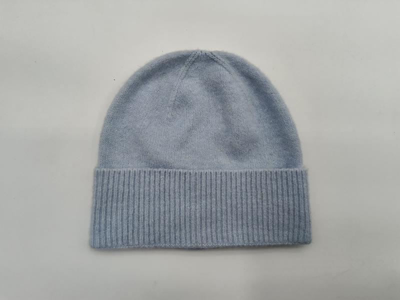 Light blue soft knit beanie hat with wide ribbed cuff, laid flat on white background, cashmere-style winter cap