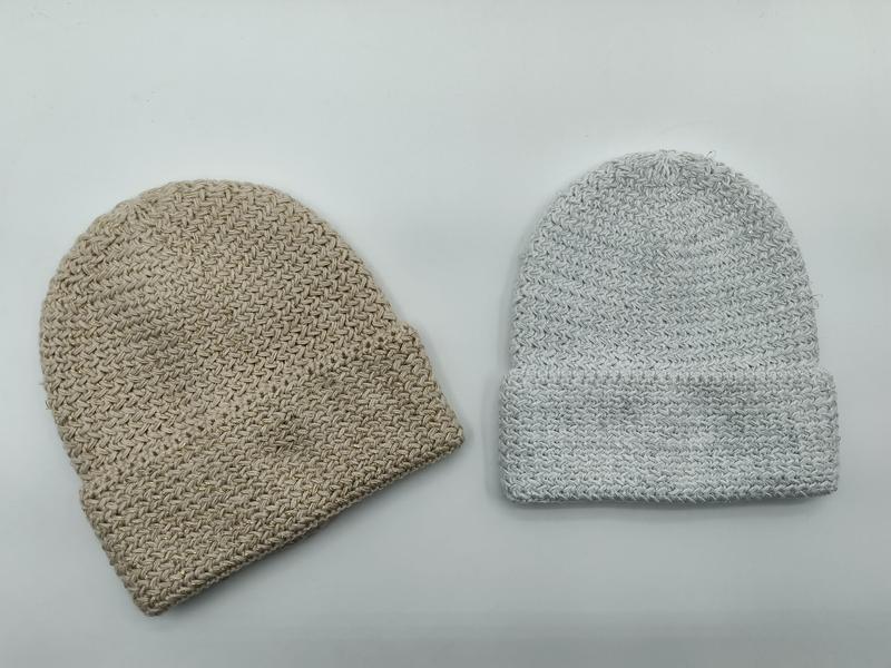 Two chunky knit beanie hats side by side, one beige without cuff and one light gray with folded cuff, on white background