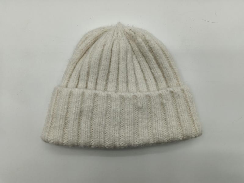 Cream off-white chunky ribbed knit beanie hat with folded cuff, laid flat on white background
