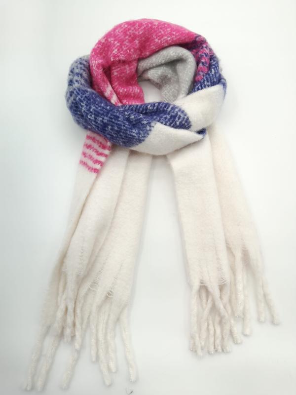 Coiled oversized winter scarf in pink, blue, and cream plaid pattern with long fringe tassels on white background