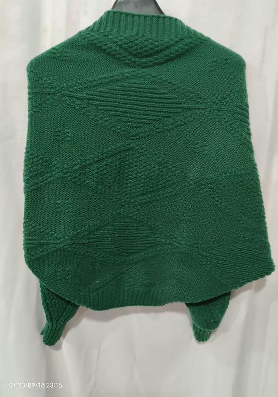 Back view of emerald green chunky knit poncho sweater with diamond geometric texture pattern displayed on hanger