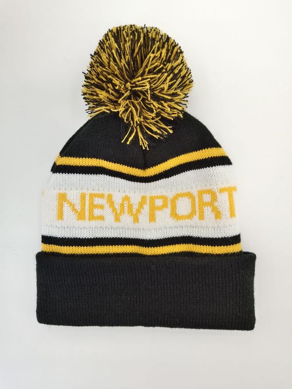 Black white and yellow striped knit beanie hat with Newport text and large black yellow pom-pom on white background