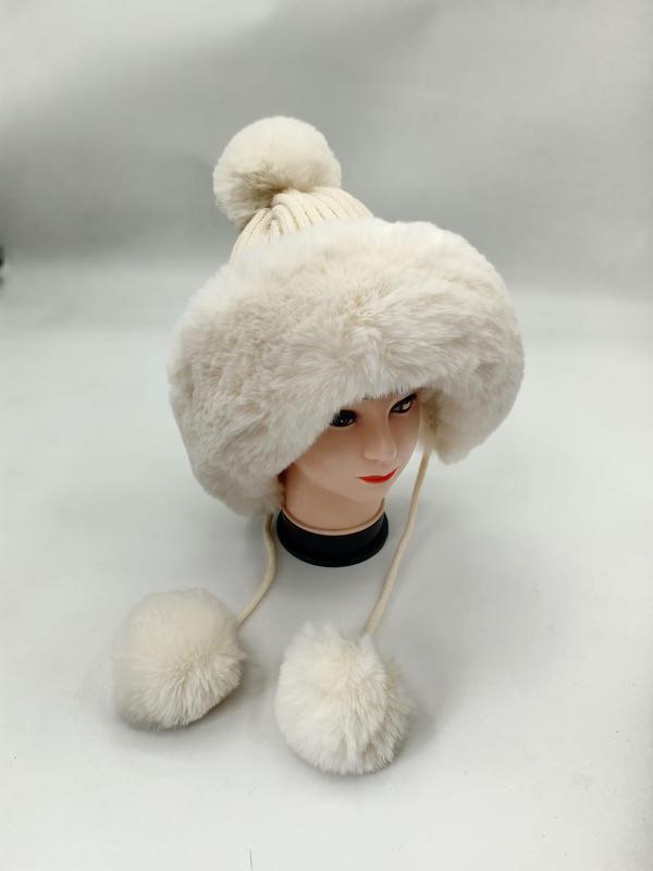Cream white faux fur trapper hat with knit pom pom top and dangling fur pom pom ties on mannequin head