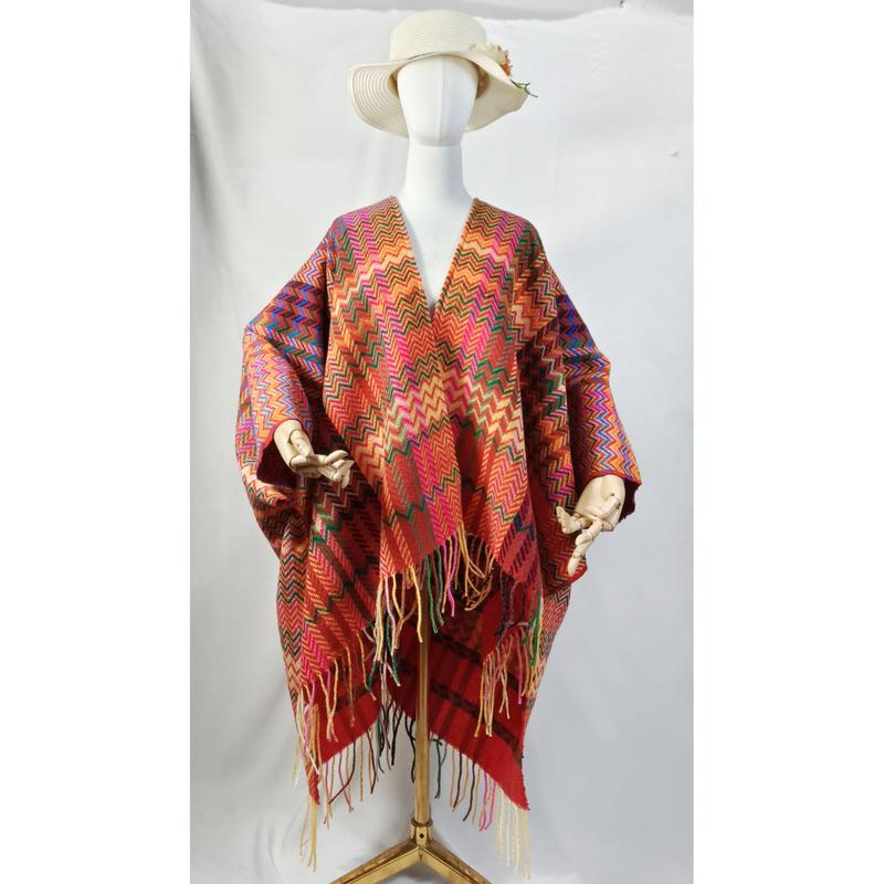 White mannequin wearing a multicolor chevron zigzag woven poncho wrap with fringe hem and wide-brim sun hat