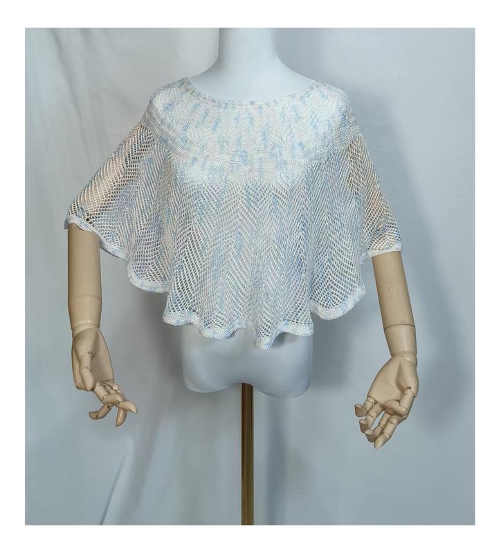 White and light blue open-weave crochet mesh poncho cape top displayed on a mannequin with wooden arms