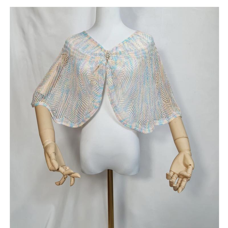 Pastel blue pink cream open-knit mesh capelet shawl with rhinestone brooch closure on white dress form mannequin
