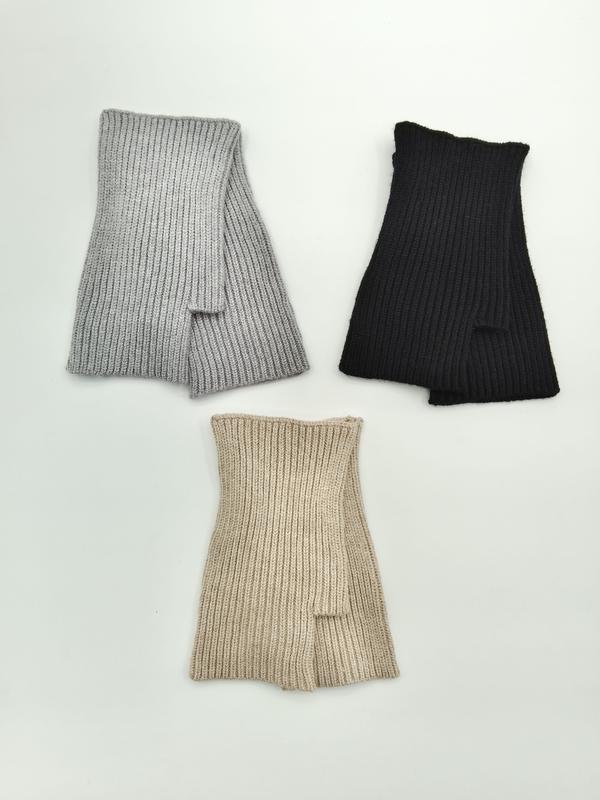 Three ribbed knit fingerless gloves laid flat in grey, black, and beige colorways on a white background