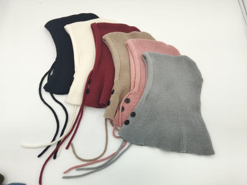 Six ribbed knit balaclava hoods in navy, cream, burgundy, beige, pink, and gray with button closures and tie strings