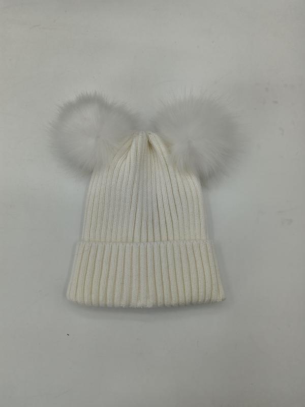 Cream white ribbed knit winter beanie hat with two fluffy faux fur pom poms on top, laid flat on white background