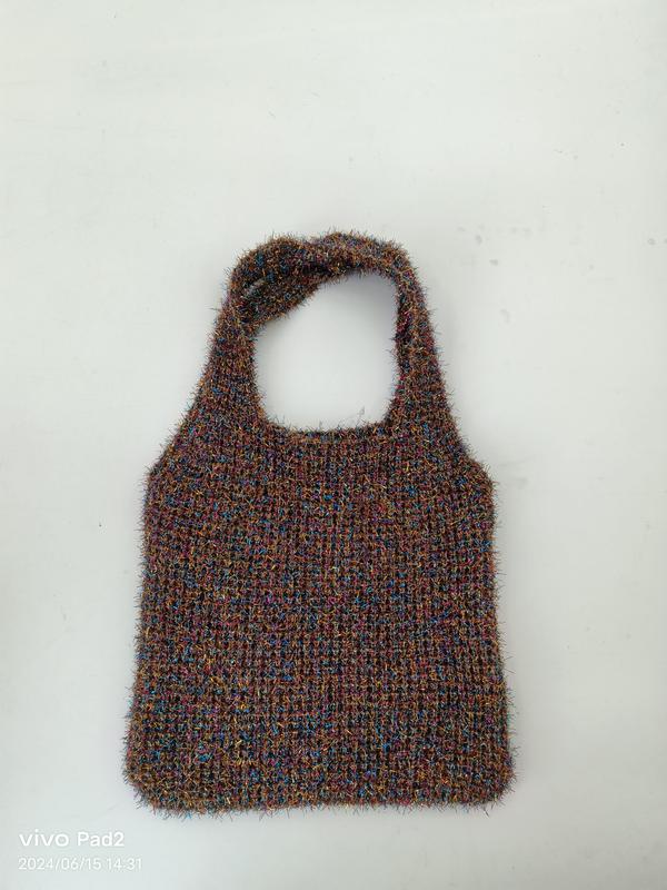 Handknit fuzzy tote bag in multicolor brown blue pink yarn with single loop handle on white background