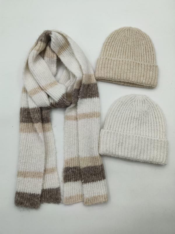 Two ribbed knit beanie hats in beige and cream with a matching striped knit scarf in neutral tones on white background