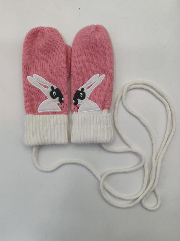 Pink knitted toddler mittens with black and white bunny appliqué and white ribbed cuffs connected by a long cord string