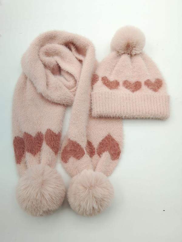 Pink fluffy knit winter beanie hat and scarf set featuring rose heart pattern and faux fur pom pom accents on white background