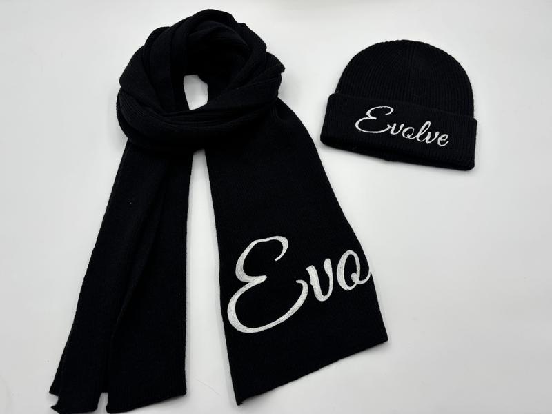 Black ribbed knit winter scarf and beanie hat set with white embroidered cursive text on white background