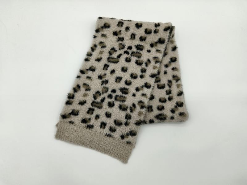 Folded beige faux fur scarf with black and brown leopard spot print pattern on white background