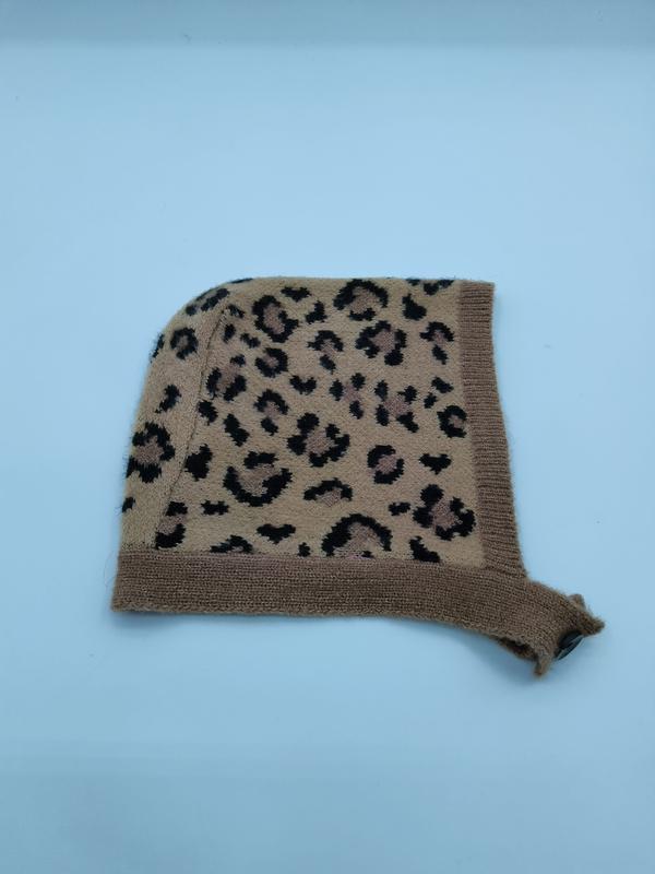 Camel brown leopard print knit baby bonnet hat with ribbed trim and tie, laid flat on white background
