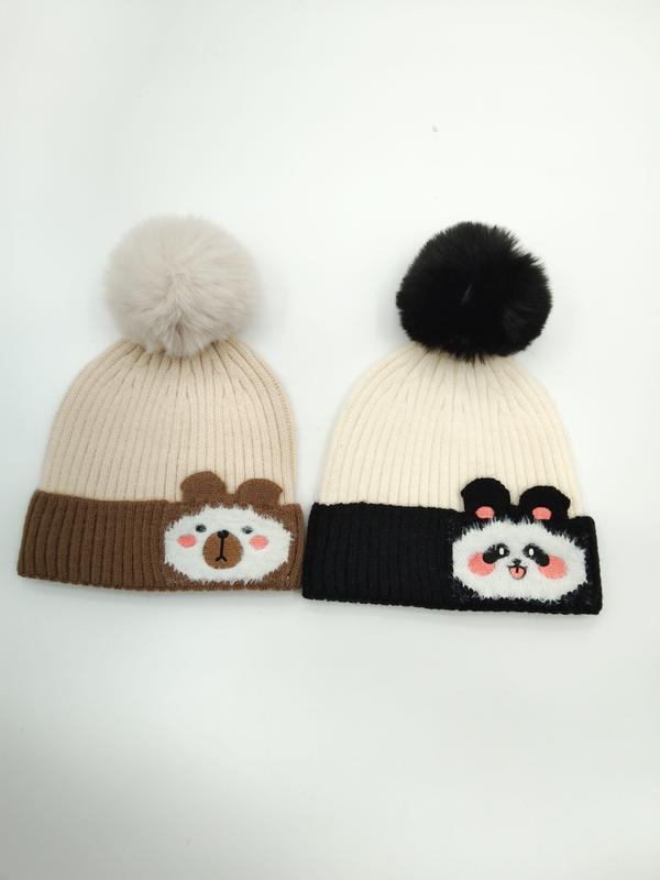 Two ribbed knit beanies with pom-poms featuring bear and panda cartoon faces on brown and black contrast cuffs