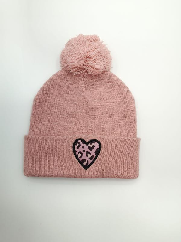 Dusty pink knit winter beanie hat with fluffy pom-pom on top and black-outlined leopard print heart patch on cuff
