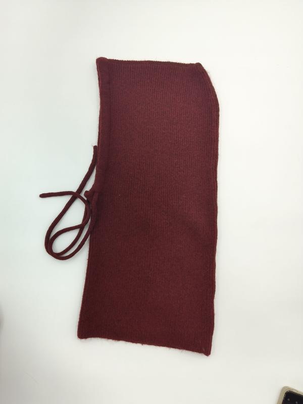 Flat lay of a dark red ribbed knit neck warmer with drawstring tie, placed on white background