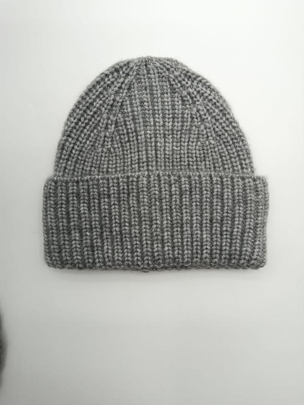 Flat lay of a heather grey chunky ribbed knit beanie hat with folded cuff on white background