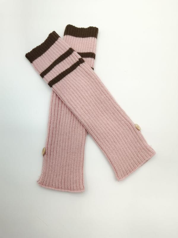 Pair of pink ribbed knit fingerless arm warmers with brown striped cuffs and small wooden buttons on white background